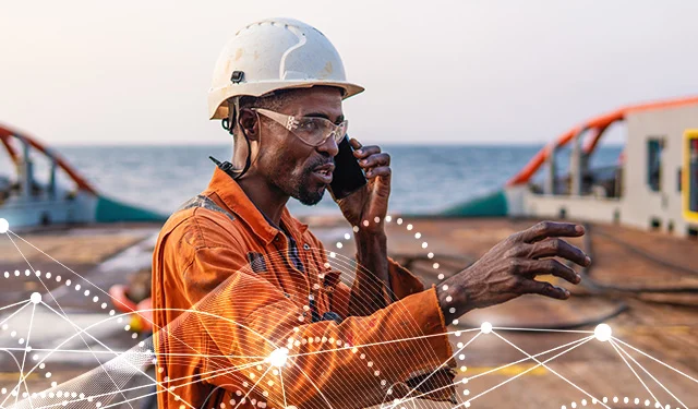 Photo d'un membre d'équipage d'une plateforme offshore, au téléphone grâce à la connexion satellite internet
