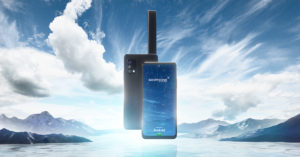 Photo du téléphone Skyphone vu de face et de dos sur un fond de ciel/mer et montagne.