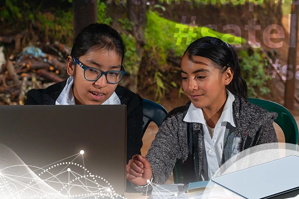 Photo de jeunes filles en train de travailler sur un ordinateur dans une zone reculée grâce à une antenne Starlink